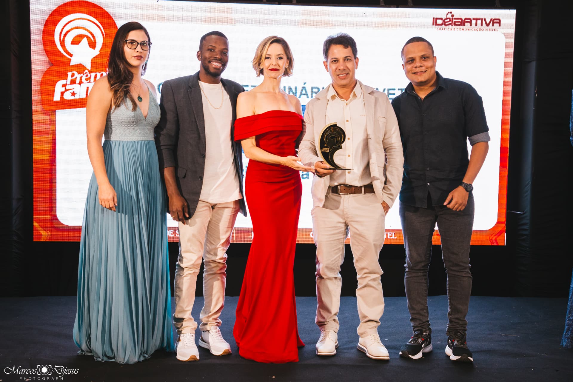 Grupo de cinco pessoas posando em frente ao painel do Prêmio Fama em Jequié