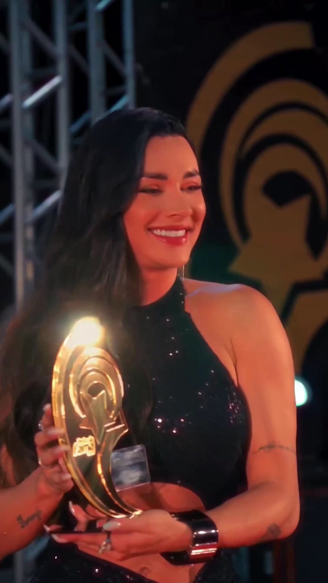 Juju Salimeni segurando o troféu do Prêmio Fama no palco
